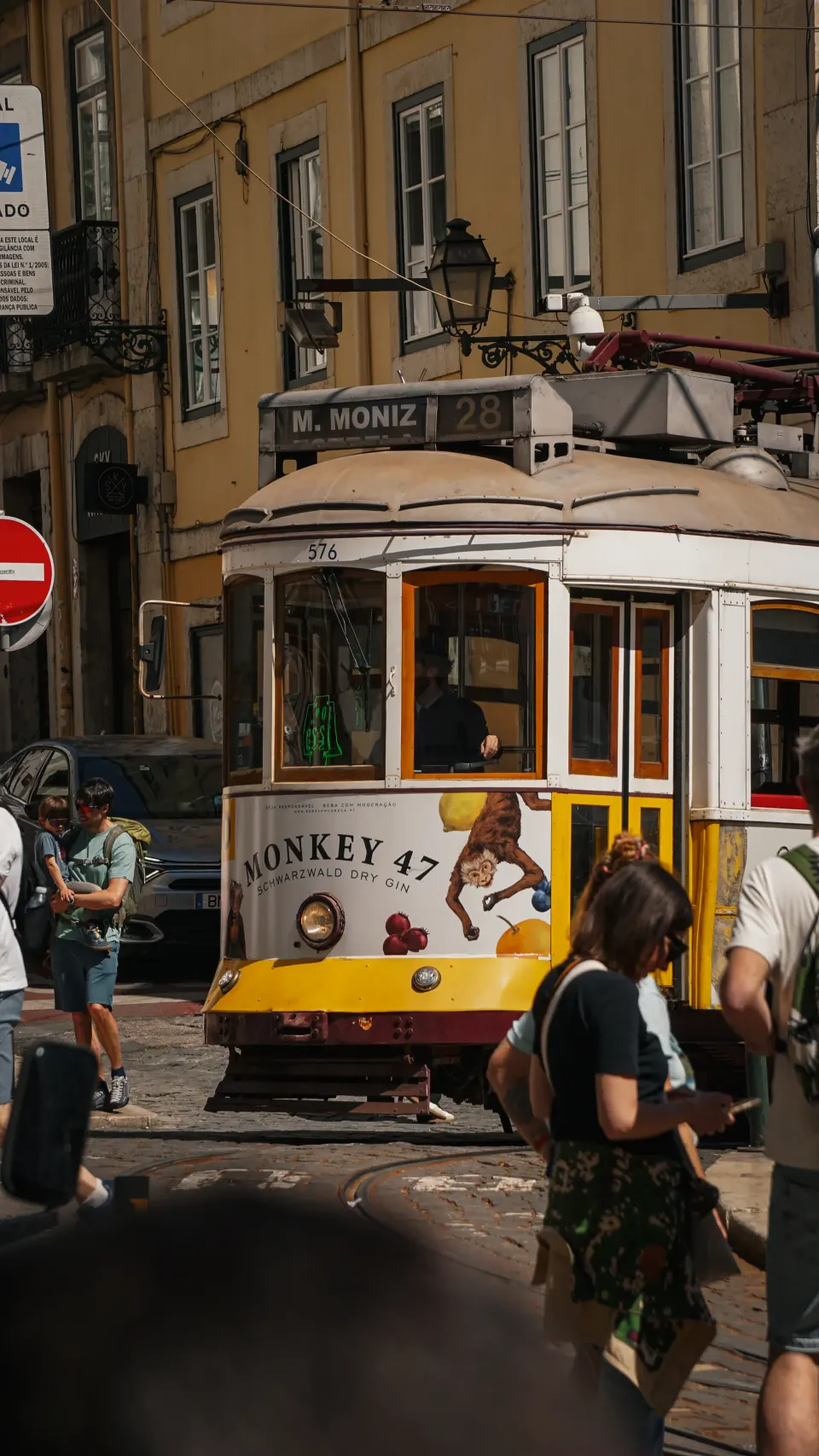 Gelbes Tram an der Haltestelle Martim Moniz in Lissabon, davor Passanten